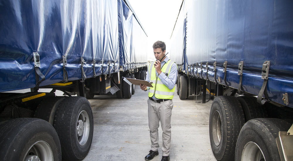Workman checking a truck consignment in a large warehouse